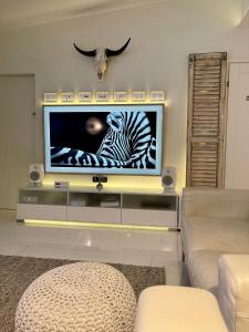 a living room with a television with a zebra on the screen at Design Guesthouse Laanila in Oulu