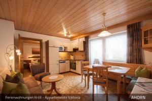 eine Küche und ein Wohnzimmer mit einem Tisch und einem Esszimmer in der Unterkunft Ferienwohnungen Kröll - Appartements Viktoria und Landhaus Maria in Mayrhofen