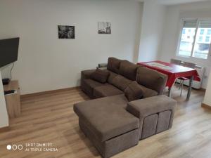 uma sala de estar com um sofá e uma mesa em nuevo centrico y 15 min cerca de aguas termales em Ourense