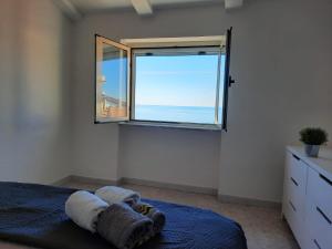 a bedroom with a window with a view of the ocean at Petra Marina Aurora in Pisciotta