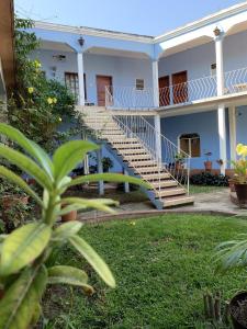 a white house with stairs in the yard at Hotel Izala in San Pedro Pochutla