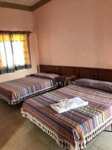 2 letti in camera d'albergo con asciugamani di Hotel Izala a San Pedro Pochutla