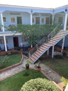 a white house with a staircase in the yard at Hotel Izala in San Pedro Pochutla