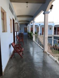 un corridoio di un edificio con due panche di legno di Hotel Izala a San Pedro Pochutla