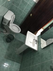 a bathroom with a toilet and a sink at Hotel Izala in San Pedro Pochutla