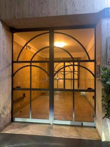 a large glass door in a room with a wooden floor at B&B APARTAMENTS Milano Bocconi in Milan