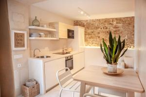 małą kuchnię z drewnianym stołem i rośliną w obiekcie 8 - LA GUARIDA DE TARIFA - Bajo B - ENJOY TARIFA w mieście Tarifa +23 zdjęcia