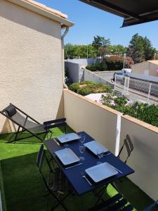 niebieski stół i krzesła na balkonie w obiekcie T2 Bis Design et Lumineux à 200m du Village Naturiste w Cap d'Agde