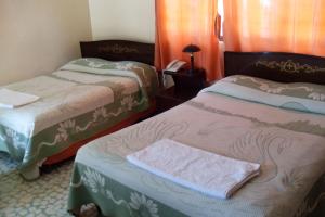 Habitación con 2 camas y toalla. en Hotel Zaragoza en Puebla