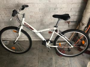 a white bike parked next to a brick wall at « Les 3 Moussaillons » appartement 2 ch Coxyde in Koksijde