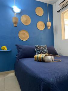 a bedroom with a blue wall with baskets on the wall at Casa San Juan in Cartagena de Indias