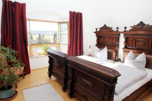a bedroom with a large wooden bed with red curtains at Ultra Alpes Ludwig Suite in Rottenbuch