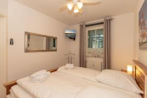 キュールングスボルンにあるHaus-Meeresblick-Wohnung-4-09-99のベッドルーム1室(ベッド2台、鏡、窓付)