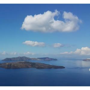 una isla en un cuerpo de agua con un cielo nublado en NEOKLASSIKO KOUKOULI, en Fira