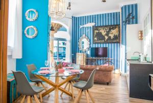 a living room with blue walls and a table and chairs at Popeye Suite Puerto Marina espectacular apartamento dentro de la Isla de Puerto Marina con Piscina en cubierta y a 1 minuto de la playa in Benalmádena