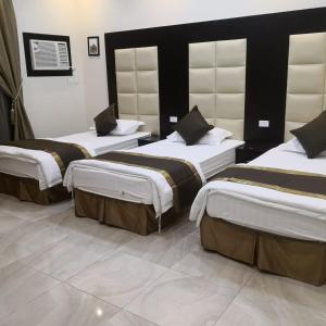 three beds in a hotel room with at روح الأصيلة للشقق المخدومة Roh Alaseilah Serviced Apartments in Taif