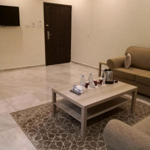 روح الأصيلة للشقق المخدومة Roh Alaseilah Serviced Apartments في الطائف: غرفة معيشة مع طاولة قهوة وأريكة