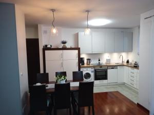 a kitchen with a dining room table with chairs at Apartament B & S - Free Garage Parking in Szczecin