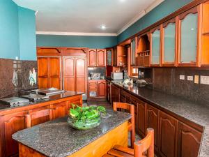 una cocina con armarios de madera y un bol de verduras en una encimera en Casa Veraneras de San Fernando, en Cali
