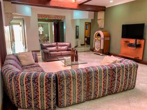 a living room with a couch and a tv at Casa Veraneras de San Fernando in Cali