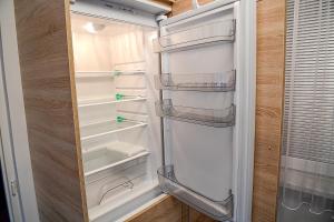 um frigorífico branco com a porta aberta numa cozinha em Apartmán Lydie em Karolinka