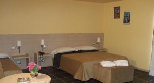 a hotel room with two beds and a table at Tus'Hotel in Castel di Tusa