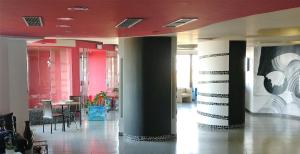 a lobby with tables and chairs in a building at Tus'Hotel in Castel di Tusa