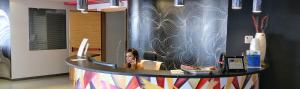 a woman sitting at a counter in a room at Tus'Hotel in Castel di Tusa