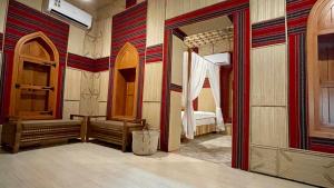 a room with a bedroom with a mirror and a bed at Fort Guesthouse نُزل القلعة in Muscat