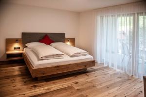 a bedroom with a bed and a large window at Willmüllerhof in Perca
