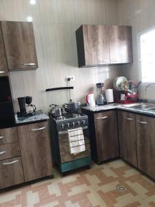 cocina con armarios de madera y horno con fogones en Well furnished and spacious 2 bedroom apartment en Abuja