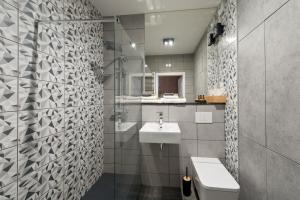 a bathroom with a white sink and a toilet at D Apartments Centrum Jurowiecka II in Białystok