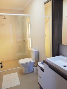 Un baño blanco con inodoro y lavabo. en Casa beira mar Torres, en Torres 18 fotos más