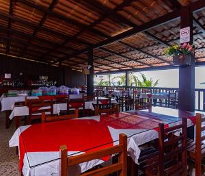 a restaurant with tables and chairs with a view of the ocean at Pousada das Flores in Angra dos Reis