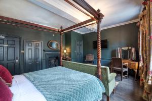 a bedroom with a canopy bed and a desk at Guy Fawkes Inn in York