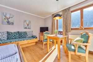 a living room with a couch and a table at Gästehaus Brandnerhof in Garmisch-Partenkirchen