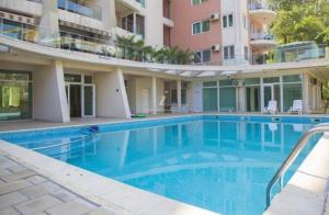 a large swimming pool in front of a building at Ale Summer Suite in Mamaia