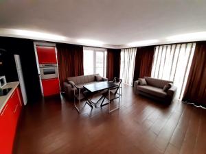 a living room with a table and chairs and a kitchen at Ale Summer Suite in Mamaia