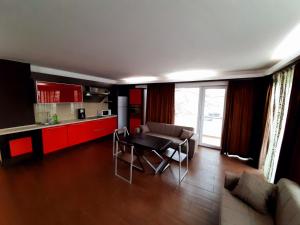 a living room with a table and a kitchen at Ale Summer Suite in Mamaia