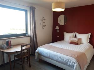 een slaapkamer met een bed, een tafel en een raam bij B&B CHEZ FOUCHS - Chambre d'hôtes in Dun-sur-Meuse