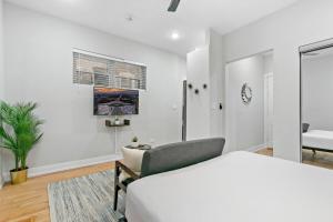 a white bedroom with a bed and a chair at Remodeled Studio Apartment in East Lakeview - Barry S1 in Chicago