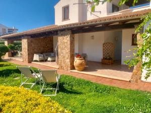 une terrasse avec 2 chaises, une table et un vase dans l'établissement Residence Solaria, à Budoni