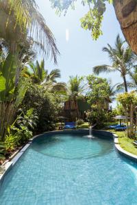 una piscina en un complejo con palmeras en Butterfly House Bahia, en Maraú