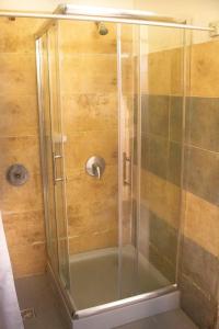 a shower with a glass door in a bathroom at Point Hostel in La Pedrera