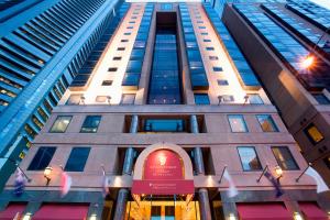 a tall building with a red sign on it at Stamford Plaza Melbourne in Melbourne