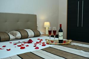 
a bed with two pillows and a bottle of wine at Oasis Deluxe Apartments in Neo Klima
