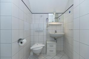 a white bathroom with a toilet and a sink at Strandschloesschen-Haus-II-WE-20-9720 in Kühlungsborn