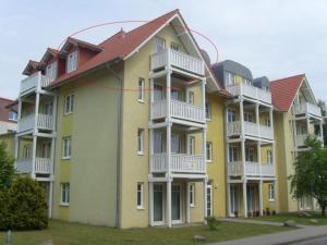 a large yellow apartment building with white balconies at Strandschloesschen-Haus-II-WE-20-9720 in Kühlungsborn