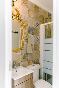 a bathroom with a toilet and a sink and a mirror at Paz & Amor Guest House - Peace & Love in Nazaré