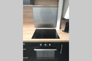 a kitchen with a stove top oven in a kitchen at Le Sweet Toulouse Purpan - Hopital & Tram à 5 minutes - Parking in Toulouse